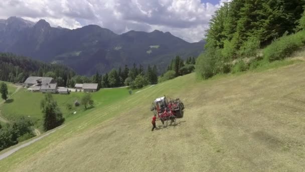 一辆拖拉机停在一座小山的中央 一个人站在外面修理什么东西 空中射击 — 图库视频影像
