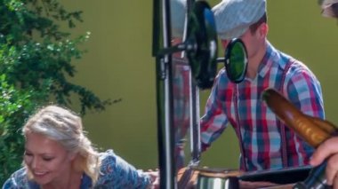 Genç bir adam ve kadın eski arabada oturmak üzere. Hepsi çok neşeli ve mutlu bir ruh hali içinde.