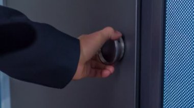 Dükkandaki lüks kapıyı test eden adamın yakın çekim görüntüleri.