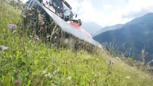 一个农民正在山上用机器割草 天气晴朗温暖 — 图库视频影像