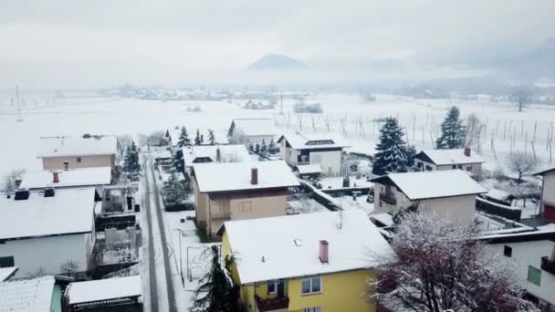 冬の間に美しい白い村 雪が降っていて 自然や通りは白く 雪に覆われています 景色は素晴らしいです 航空写真 — ストック動画