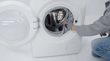 Bir tamirci, cihazı tamir edeceği için çamaşır makinesinin kauçuğundan çıkacak..