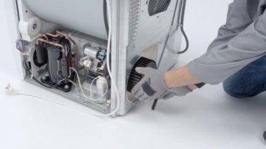 Bir tamirci çamaşır makinesine drenaj pompası filtresi tamir ediyor. Sorunun nerede olduğunu öğrenmesi gerekiyor..