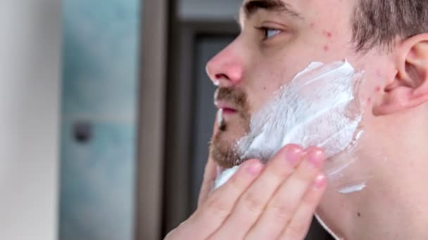 Hombre Joven Está Empezando Poner Una Espuma Afeitar Cara Luego — Vídeos de Stock