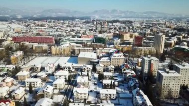 Kış zamanı. Sokaklar arasında çok fazla kar var ve evlerin çatıları da karla kaplı. Havadan çekim.