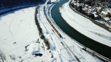 Tren raylara biniyor ve Celje kasabasındaki tren istasyonuna doğru ilerliyor. Kış zamanı. Havadan çekim.