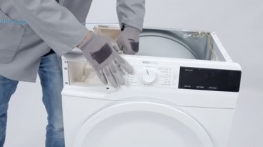 Bir tamirci bileğine bir tel takıyor ve bir kontrol paneli açıyor ve ona dokunuyor..