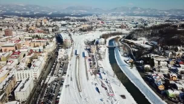 鉄道駅のある町の一部はまだ雪で覆われている 冬の時間だ航空写真 — ストック動画
