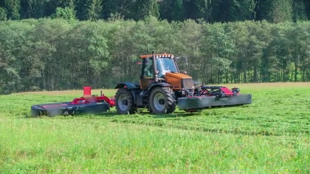 Červený Traktor Vytahuje Dva Stroje Sekání Trávy Den Krásný Slunečný — Stock video
