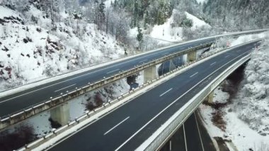 Bu soğuk kış gününde Slovenya'da bir otoyolda sadece birkaç araba sürüyor. Havadan çekim.