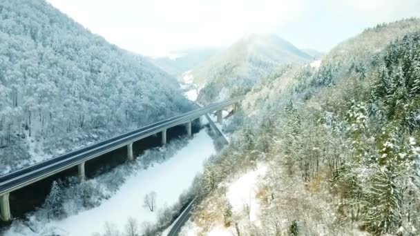 我们可以看到一座桥上的公路 它在很多山丘之间运行 冬天的时候 大自然是雪的白衣 — 图库视频影像