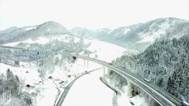 自然の真ん中に長い高速道路が見えます 冬の時間で 風景は雪で覆われています 航空写真 — ストック動画