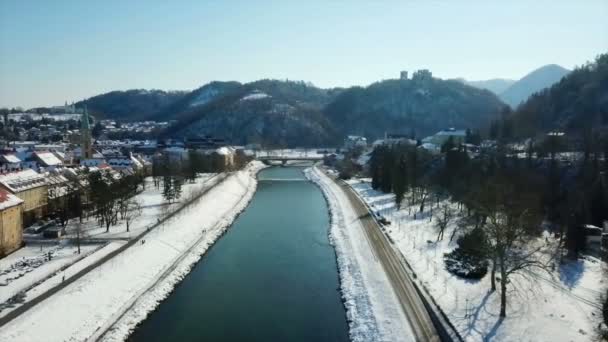 サヴィーニャ川の両岸には雪が多い 冬の時間だ背景には大きな城が見えます 航空写真 — ストック動画