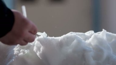 Bir adam güzel bir eşit yüzey yapıyor ve o bir saman kullanıyor.