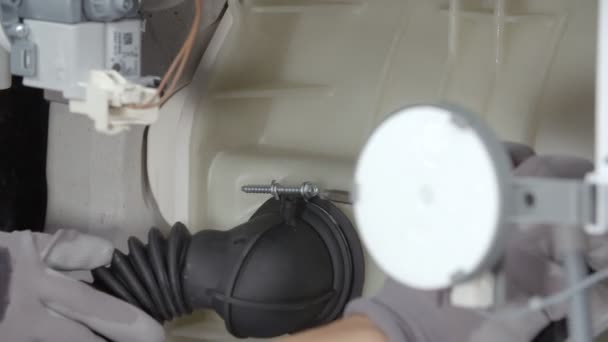 Ein Mann Repariert Eine Waschmaschine Nimmt Mit Einem Bohrer Eine — Stockvideo
