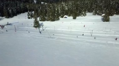 Kayakçılar kalkış asansörlerini yokuş yukarı kullanıyorlar. Kayak merkezinde güzel bir gün. Hava görüntüsü.