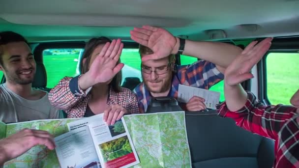 朋友们在同一时间给了对方一个击掌的机会 他们开着一辆面包车 正在看地图 — 图库视频影像