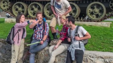 Bir grup genç eski bir duvarda oturuyor ve hangi yöne gideceklerini düşünüyorlar..