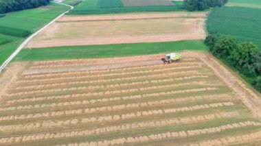 Bir kombine sahada sürüyor ve çizgiler çiziyor. Hava görüntüsü. Yaz mevsimindeyiz. Çevredeki doğa gerçekten güzel..