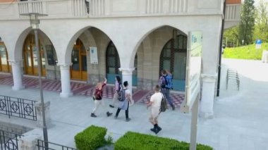 Sırt çantaları genç ve mutlular ve şehirde dolaşıyorlar. Hava görüntüsü.