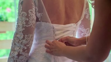 Baş nedime gelinin düğün gününe hazırlanmasına yardım ediyor..