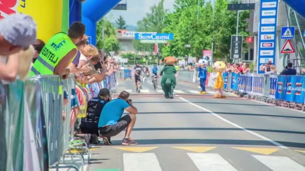 フィニッシュラインのすぐ前で ロードバイクレーサーの一人が自転車と一緒に走っています そこにも3つのマスコットがあります — ストック動画