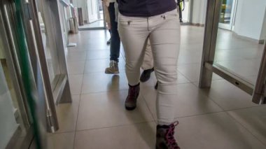 Cam kapı otomatik olarak açılır ve bir grup genç içeri girer..