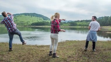 Üç arkadaş gölün suyuna taş atıyorlar. Eğleniyorlar..