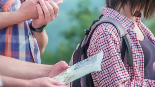 A group of young people is looking on a map in front of them. They're out on a trip together. — Stock Footage Group Young People Looking Map Front Them Out Trip Together Stock Video