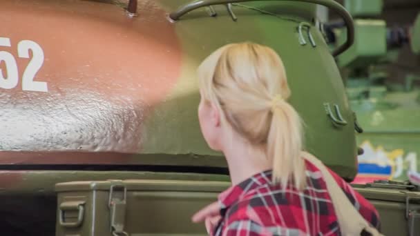 Een Jonge Vrouw Wijst Naar Een Nummer Militaire Tank Haar — Stockvideo