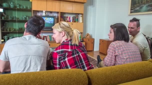 一群五个朋友坐在客厅的沙发上 一边看电视 一边谈论着什么 — 图库视频影像