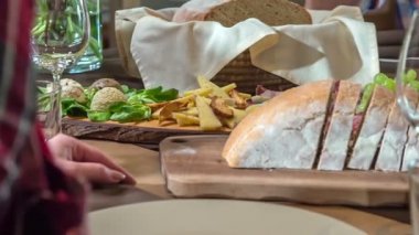 Lezzetli bir aperatif misafirlerin önünde masada. Peynir ve üzümlerin yanında ekmek ve soğuk et de var..