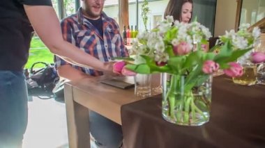 Garsonun biri, süzme peynirden yapılmış lezzetli bir tatlıyı bir misafirin önünde masaya koyar..