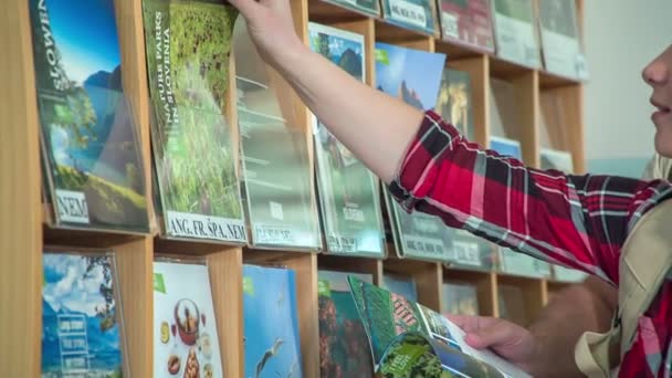 Dois Jovens Estão Verificar Brochuras Línguas Diferentes Numa Agência Turismo — Vídeo de Stock