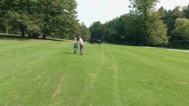 Ein Junges Paar Umarmt Und Tanzt Inmitten Einer Riesigen Rasenfläche — Stockvideo