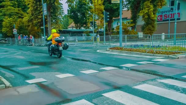 Ein Rennradrennfahrer Roten Outfit Fährt Hinter Einem Motorradfahrer Her — Stockvideo