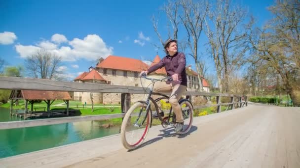 Imágenes Joven Montando Bicicleta Puente Cerca Del Castillo — Vídeos de Stock