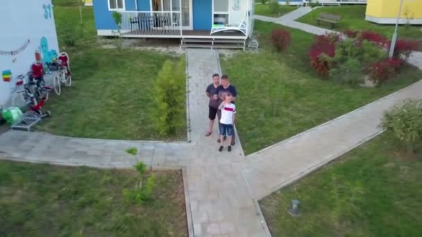 Drie Mannen Staan Voor Het Vakantiehuis Jongen Zwaait Luchtfoto — Stockvideo