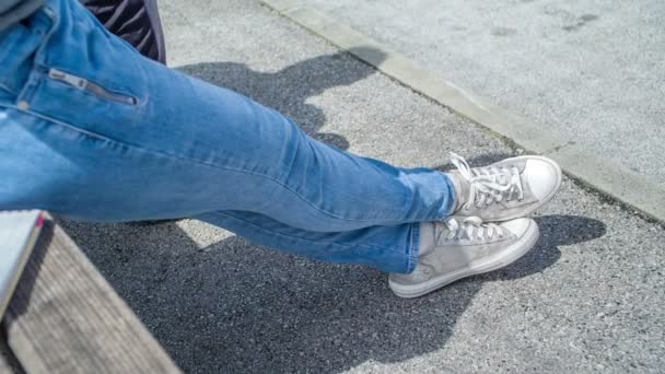 Frau Mit Weißen Turnschuhen Sitzt Auf Einer Bank Und Hängt — Stockvideo