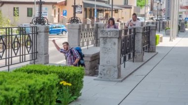 Genç bir adam birine el sallıyor ve diğerleri onun peşinden geliyor. Güzel bir gün ve hava yürümek için mükemmel..