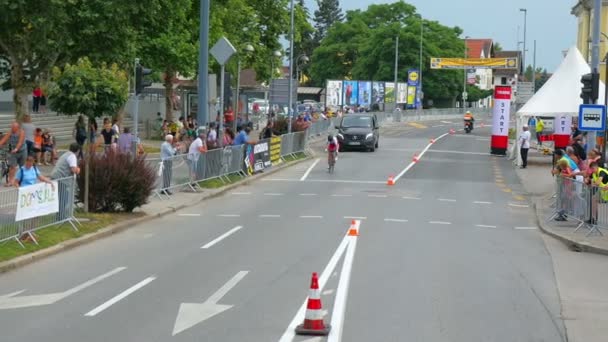 Egy Fekete Autó Követ Egy Kerékpárost Elkíséri Országúti Kerékpárversenyen — Stock videók