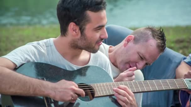 Joven Toca Una Guitarra Entretiene Sus Amigos Todos Están Pasando — Vídeos de Stock