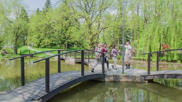 Grupo Jóvenes Cruza Puente Parque Todas Partes Hay Agua Naturaleza — Vídeos de Stock