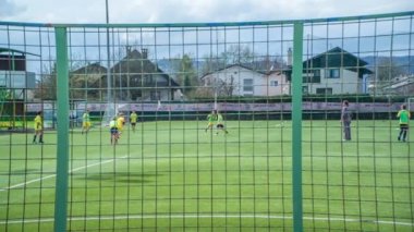 Çocuklar futbol sahasında futbol oynuyorlar. Topun peşindeler..