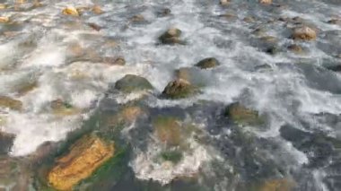 Nehrin sudaki büyük taşların üzerinden akması gerekiyor. Yaz mevsimindeyiz. Hava görüntüsü.