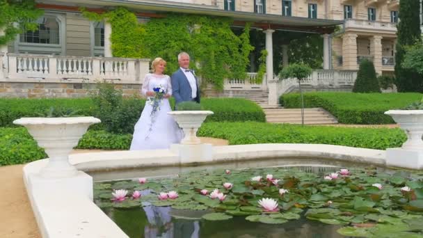 Жених Невеста Стоят Пруда Парке Жених Бросает Счастливую Монету Воду — стоковое видео