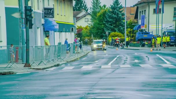 バイク乗り ロードバイシクルレーサー 車が次々と運転しています 道路は濡れて滑りやすい — ストック動画