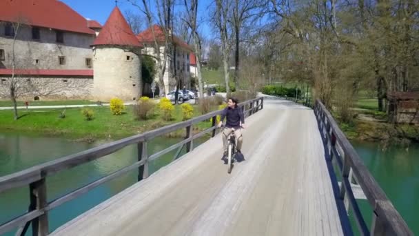 Imágenes Joven Montando Bicicleta Puente Cerca Del Castillo — Vídeos de Stock