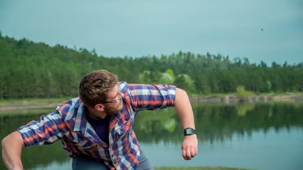 Ung Man Kastar Sten Ett Vatten Fin Och Solig Dag — Stockvideo