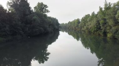 Her iki nehir kıyısındaki ağaçların arasında bir nehrin saklı olduğunu görebiliyoruz. Çok huzurlu bir gün..